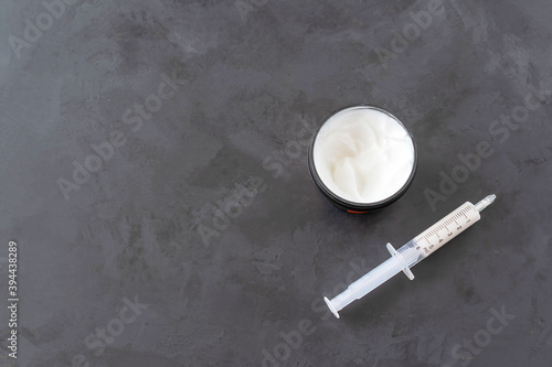 Face cream in a medical syringe. Beauty concept. photo