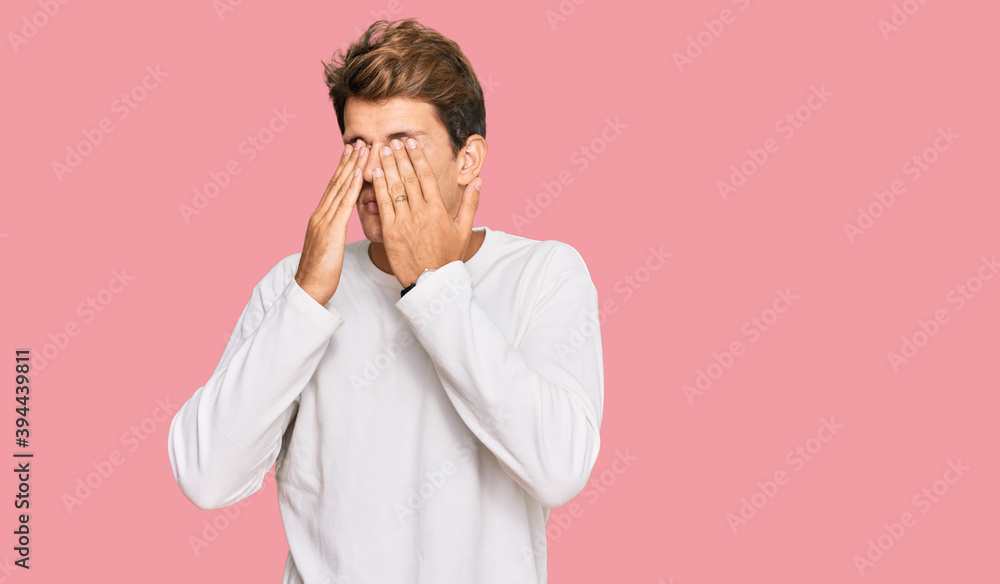 Handsome caucasian man wearing casual white sweater rubbing eyes for fatigue and headache, sleepy and tired expression. vision problem Handsome caucasian man wearing casual white sweater rubbing eyes for fatigue and headache, sleepy and tired expression. vision problem