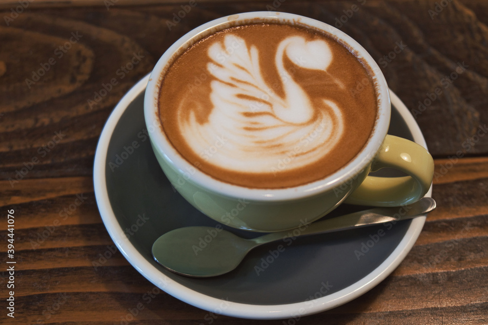 Coffee time - ceramics cup of excellent cappuccino with coffee art swan Coffee time - ceramics cup of excellent cappuccino with coffee art swan