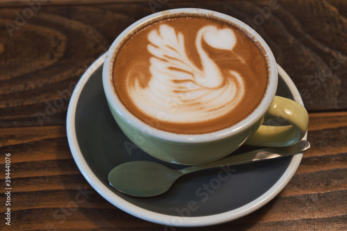 Coffee time - ceramics cup of excellent cappuccino with coffee art swan