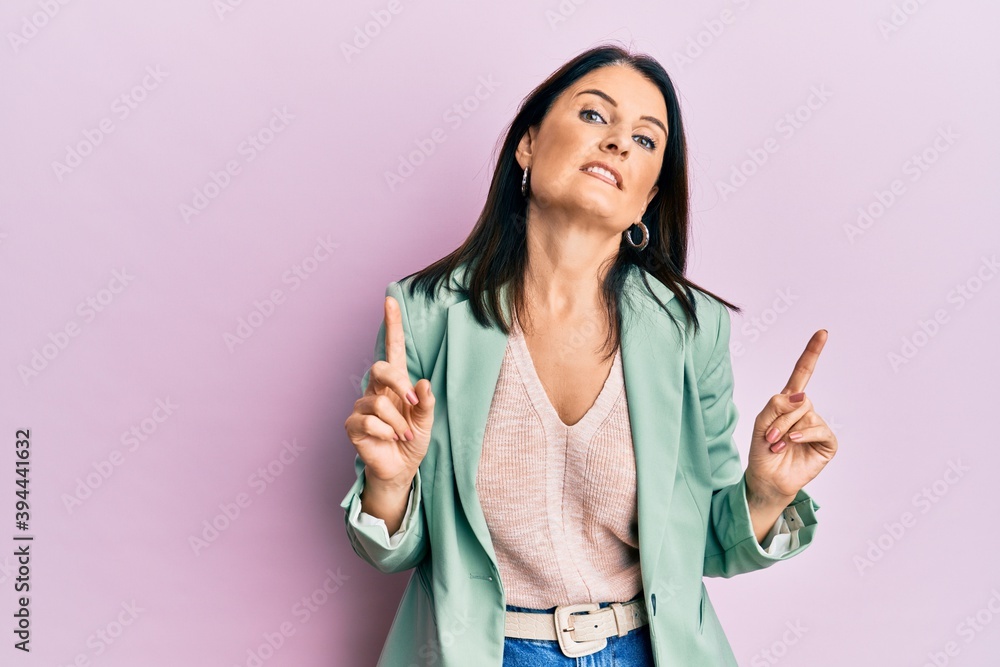 Middle age brunette woman wearing casual clothes smiling confident pointing with fingers to different directions. copy space for advertisement Middle age brunette woman wearing casual clothes smiling confident pointing with fingers to different directions. copy space for advertisement