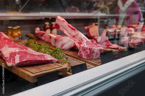Front view of fresh raw red good quality of meat through glass of counter at the butcher shop.
