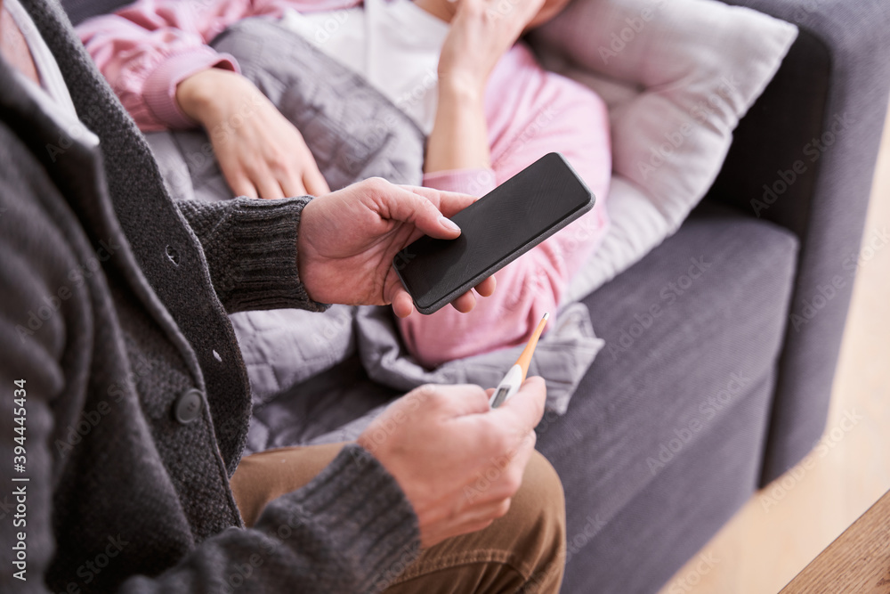 Fototapeta premium Man checking with thermometer fever temperature of his wife