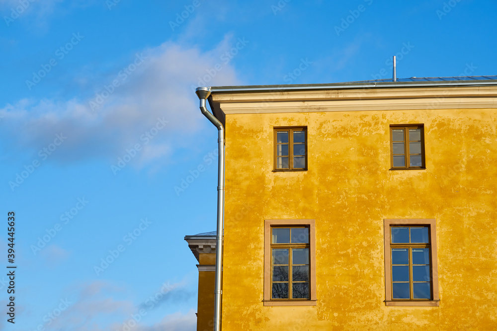 Windows in a yellow house against the blue sky. Windows in a yellow house against the blue sky.