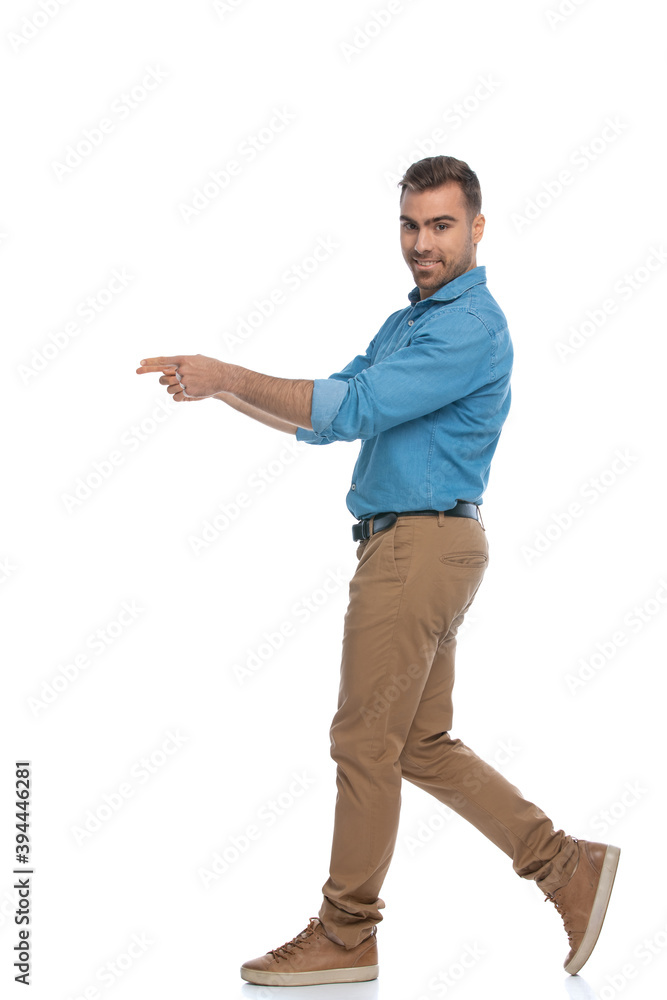 casual attractive man walking and pointing one way casual attractive man walking and pointing one way