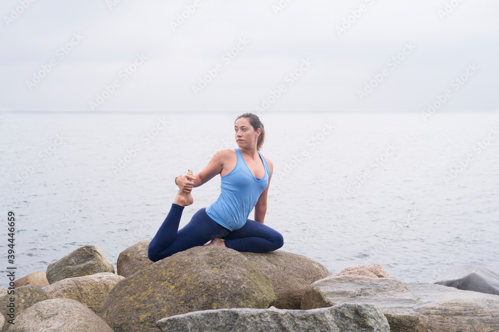 Woman stretching at sea, Sweden Woman stretching at sea, Sweden
