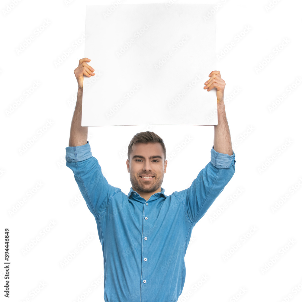 casual man showing a blank board at the camera casual man showing a blank board at the camera