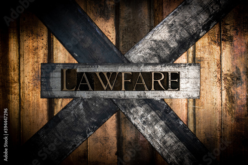 Lawfare text formed by real authentic typeset letters on vintage textured grunge bronze background