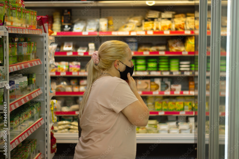Woman with mask in the supermarket during coronavirus time.
