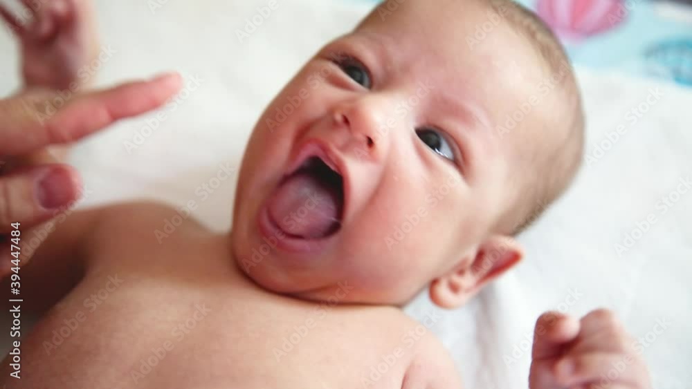 Close up shot of young mother is playing with her newborn baby in a nursery in a morning. Concept of maternity. Close up shot of young mother is playing with her newborn baby in a nursery in a morning. Concept of maternity.