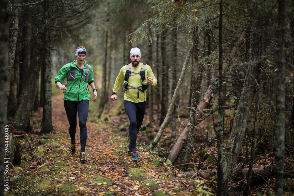 Man and woman running in forest, Sweden Man and woman running in forest, Sweden