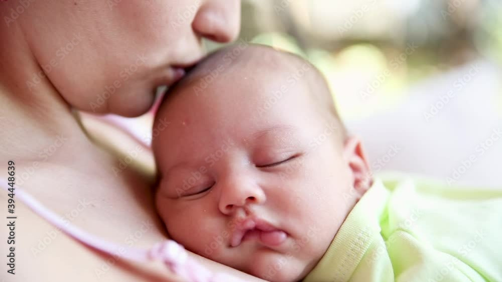 little baby boy sleeping on mom's chest outdoor. mother hugging