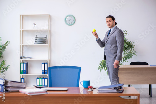 Young male employee juggling with tennis ball in the office © Elnur