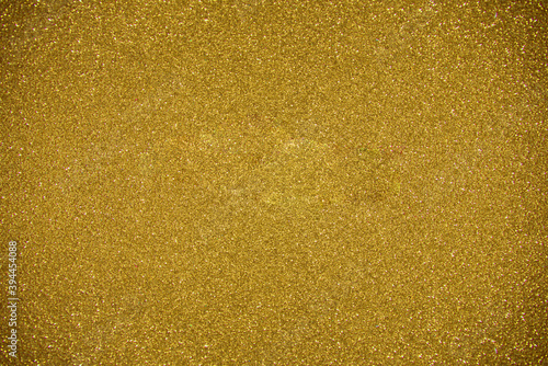 Glitter dark yellow background. Photo of monotone shiny background.