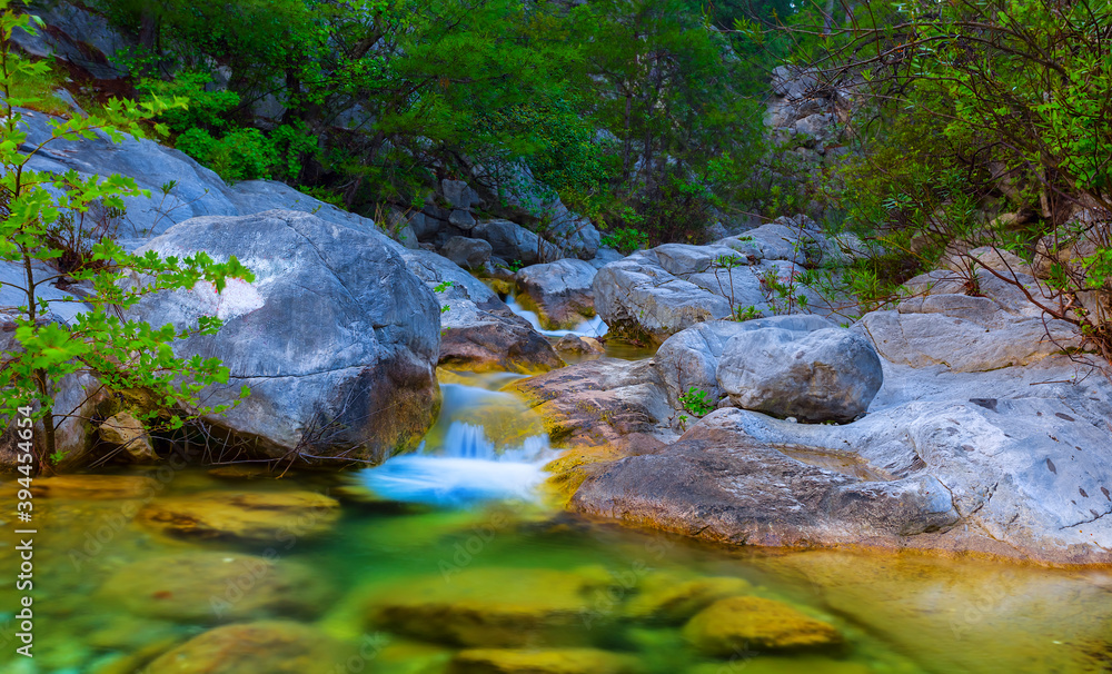 small river rushing over a stones in a mountain canyon small river rushing over a stones in a mountain canyon