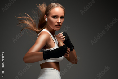 Valokuvatapetti Female boxer. Sportswoman training in boxing bandages.