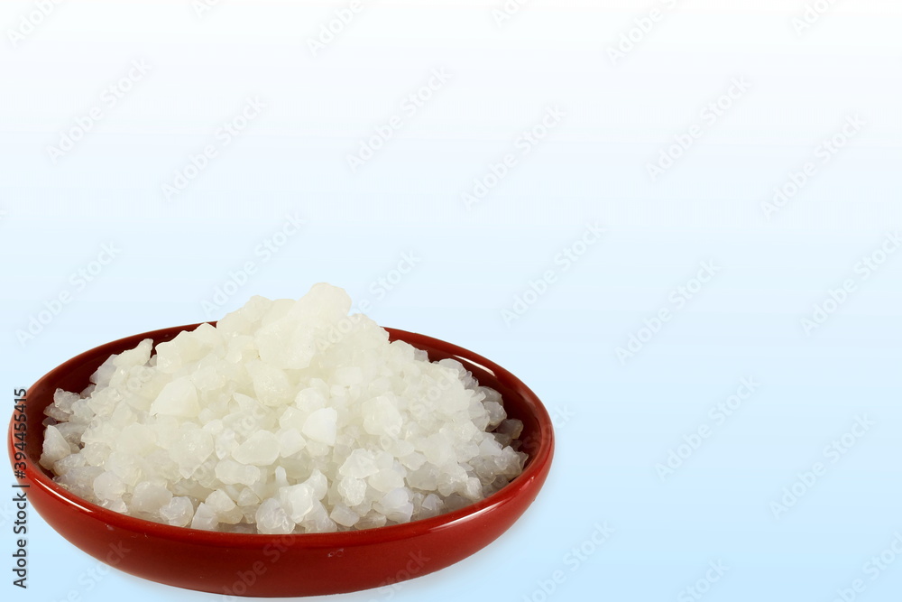 camphor or cinnamomum camphora crystal in bowl on blue white background with copy space camphor or cinnamomum camphora crystal in bowl on blue white background with copy space