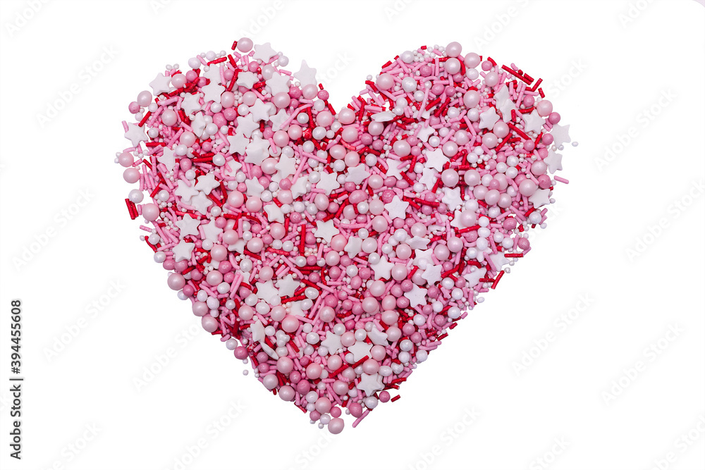 Heart of small pink pastry figures for cake decoration. Sweet pearls and, stars, sticks made up in the shape of a heart Isolated on a white background.