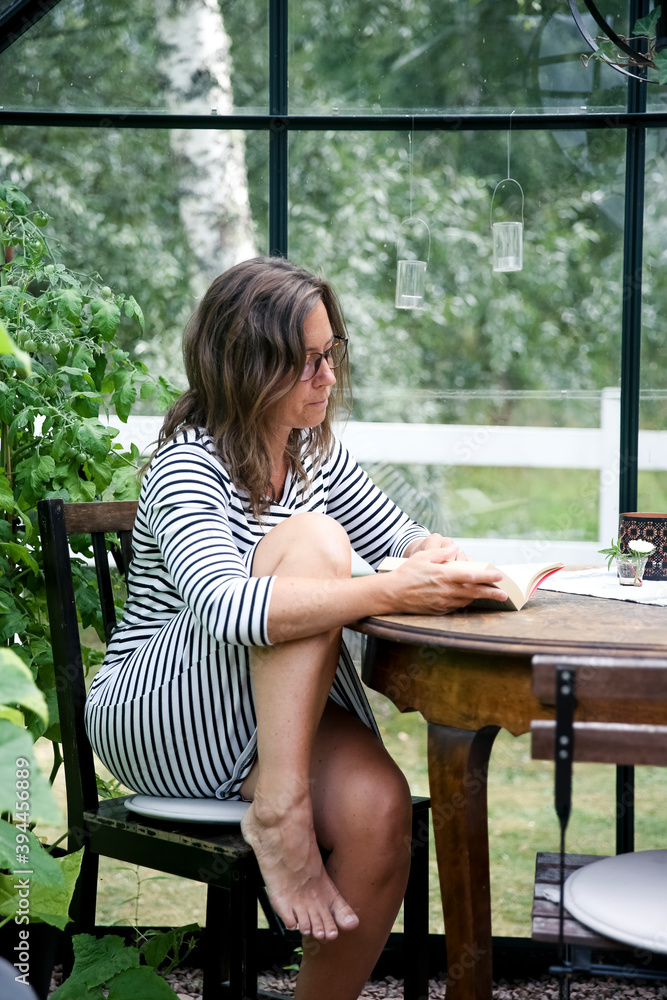 Woman reading in greenhouse, Sweden Woman reading in greenhouse, Sweden
