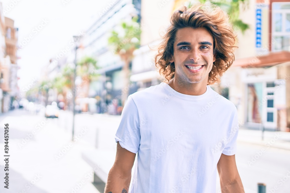 Young handsome hispanic man smiling happy walking at street of city