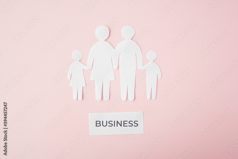 paper family cut out on bright pink background, family home, foster care, family mental health, budget and money, business concept. Paper family with phrase quote business paper family cut out on bright pink background, family home, foster care, family mental health, budget and money, business concept. Paper family with phrase quote business
