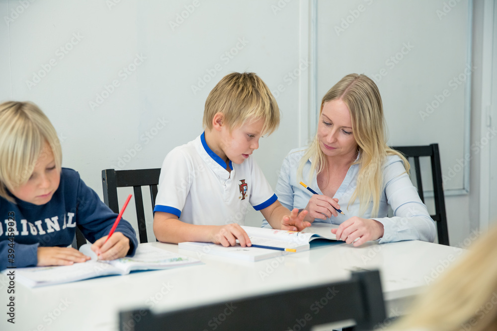 Teacher helping boy in classroom, Portugal Teacher helping boy in classroom, Portugal