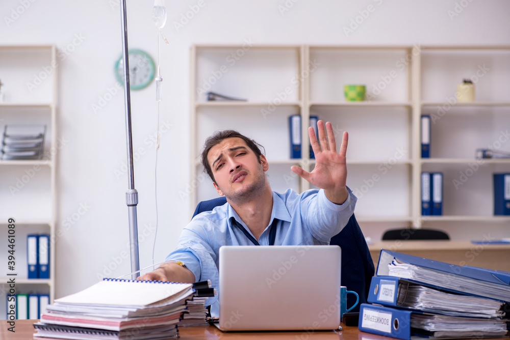 Young male employee suffering at workplace