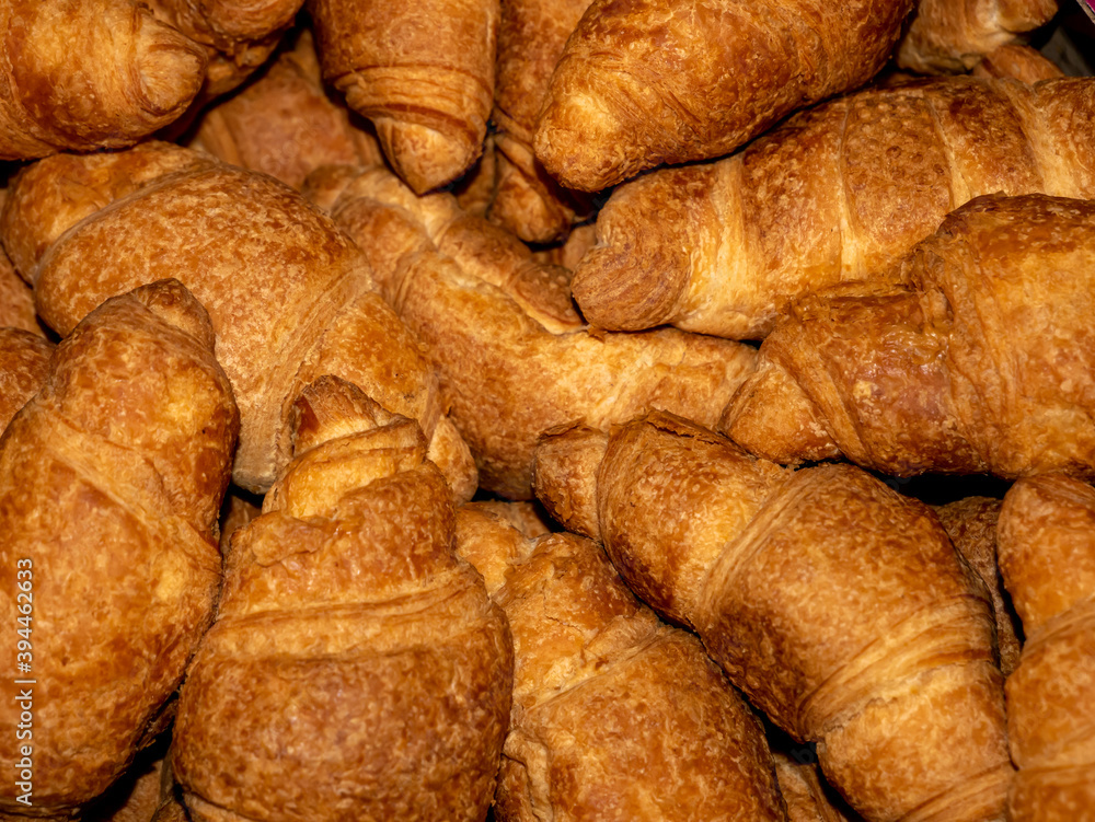 Delicious crispy yellow croissants with filling lie in a pile