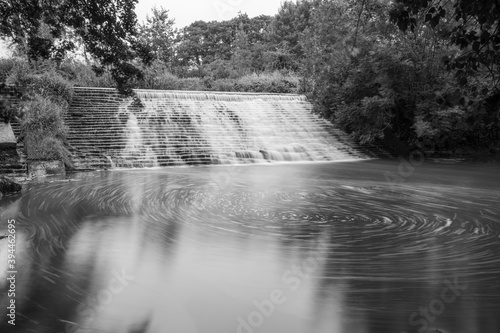 Long exposure of the River Brue flowing through the weir at West Lydford in Somerset photo