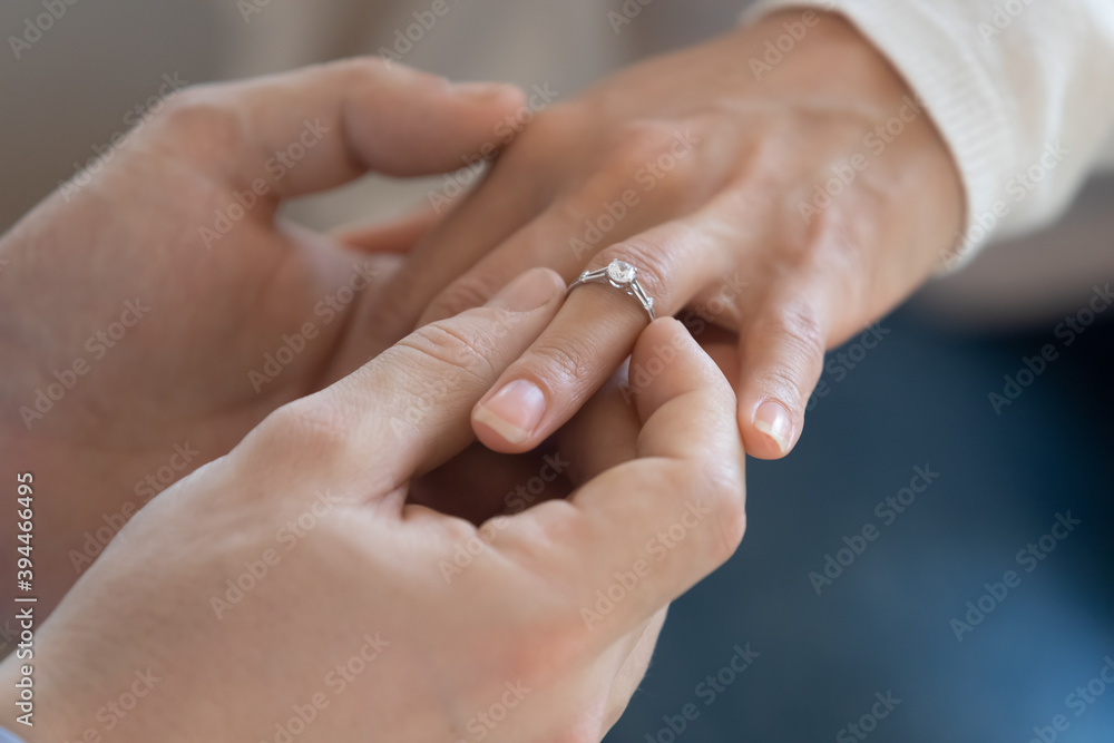 She said yes. Close up view of happy affectionate young man groom making love confession and putting engagement ring on finger of beloved woman bride as symbol of betrothal engagement wedding proposal She said yes. Close up view of happy affectionate young man groom making love confession and putting engagement ring on finger of beloved woman bride as symbol of betrothal engagement wedding proposal