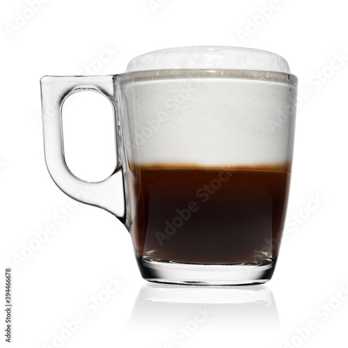 Transparent glass cup of espresso macchiato coffee isolated on white.
