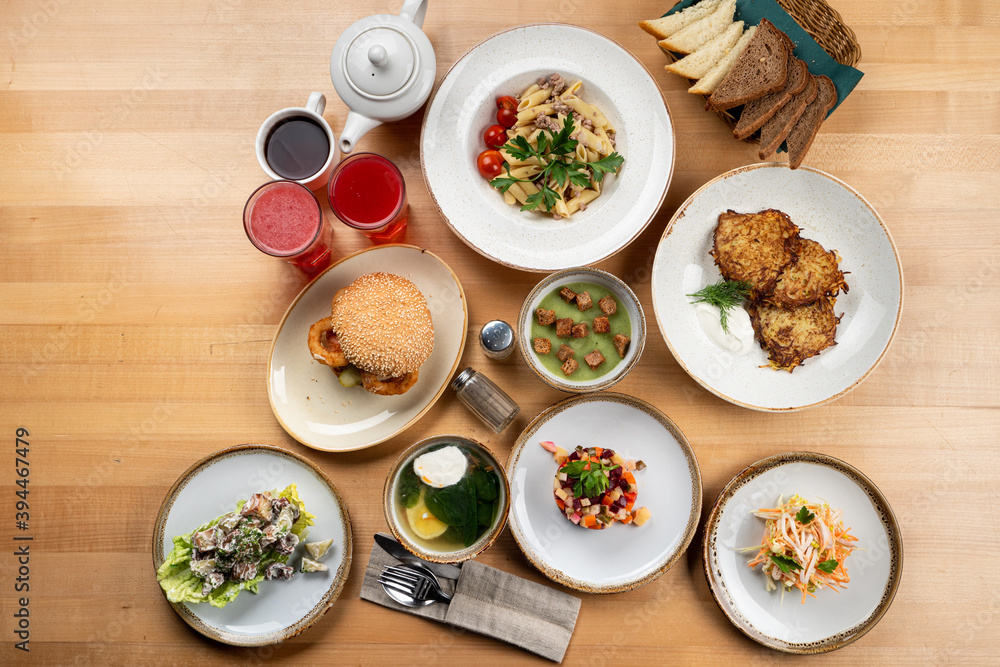 Different european meals on light wooden table, whole menu shot, directly above Different european meals on light wooden table, whole menu shot, directly above