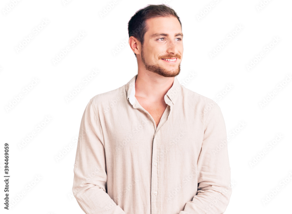 Young handsome caucasian man wearing casual clothes looking away to side with smile on face, natural expression. laughing confident. Young handsome caucasian man wearing casual clothes looking away to side with smile on face, natural expression. laughing confident.