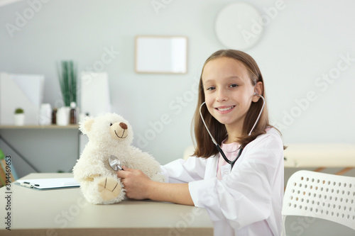 Fototapeta Naklejka Na Ścianę i Meble -  cute girl in good mood plays doctor