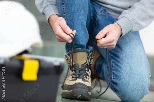 man is putting his workboots on photo