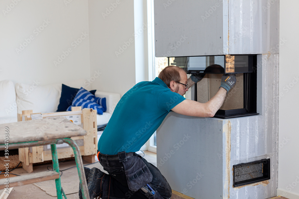 Man installing fireplace, Sweden Man installing fireplace, Sweden