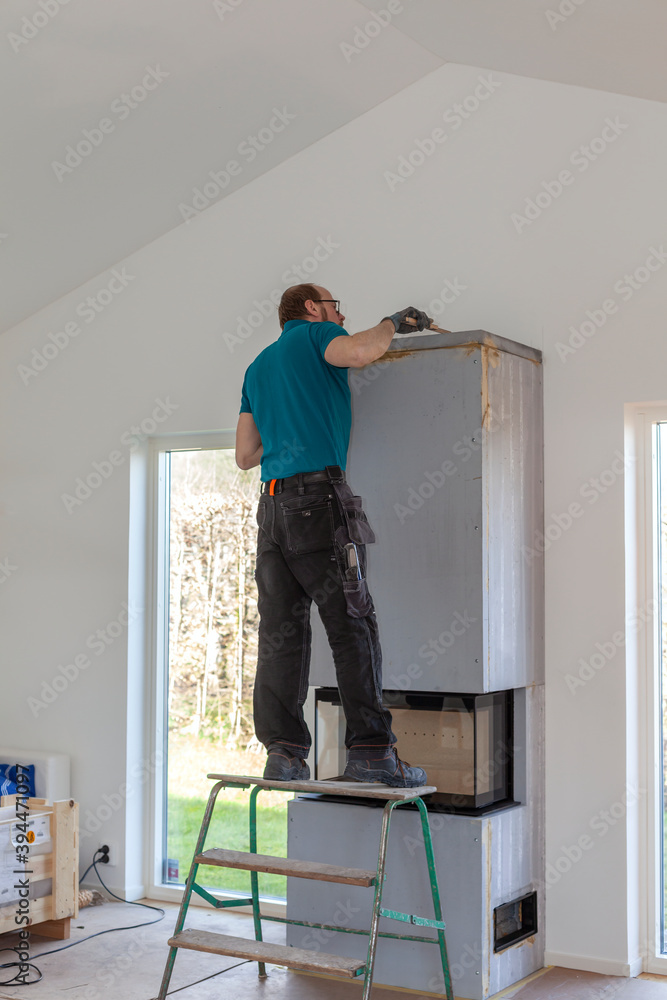 Man installing fireplace, Sweden Man installing fireplace, Sweden