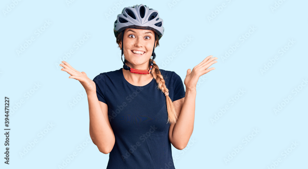 Beautiful caucasian woman wearing bike helmet celebrating crazy and amazed for success with arms raised and open eyes screaming excited. winner concept Beautiful caucasian woman wearing bike helmet celebrating crazy and amazed for success with arms raised and open eyes screaming excited. winner concept