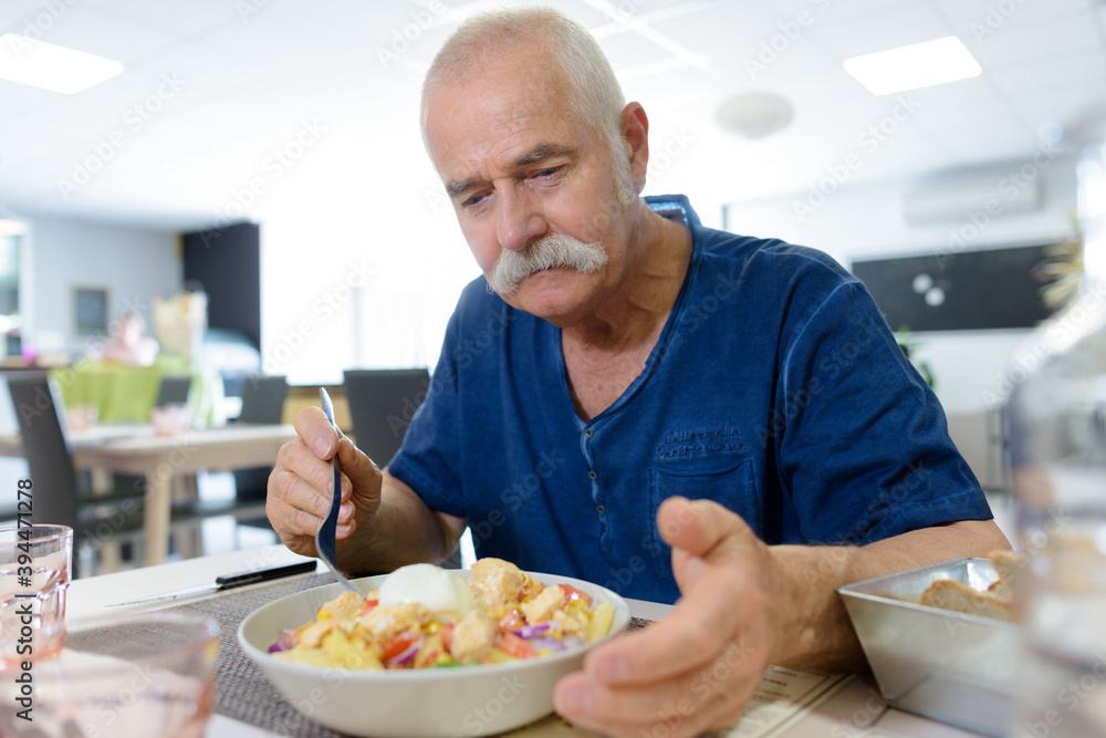 senior man eating lunch in restaurant
