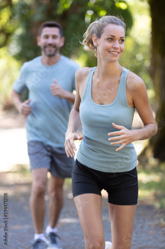 portrait of cheerful couple running outdoors