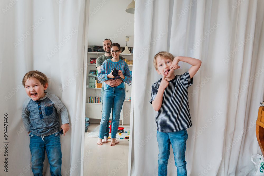 Happy boys standing near mirror, Sweden Happy boys standing near mirror, Sweden