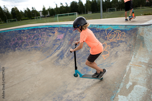 Boy on push scooter riding in skateboard park, Finland photo