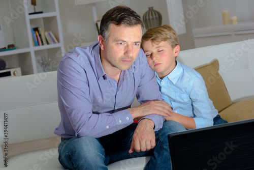 Photos Son falling asleep on father watching television