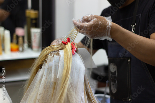 hairdresser coloring a blonde woman s hair.