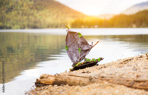 Sailing away on a small funny handmade boat by the lake. Do it yourself ship in nature. Travel concept. 