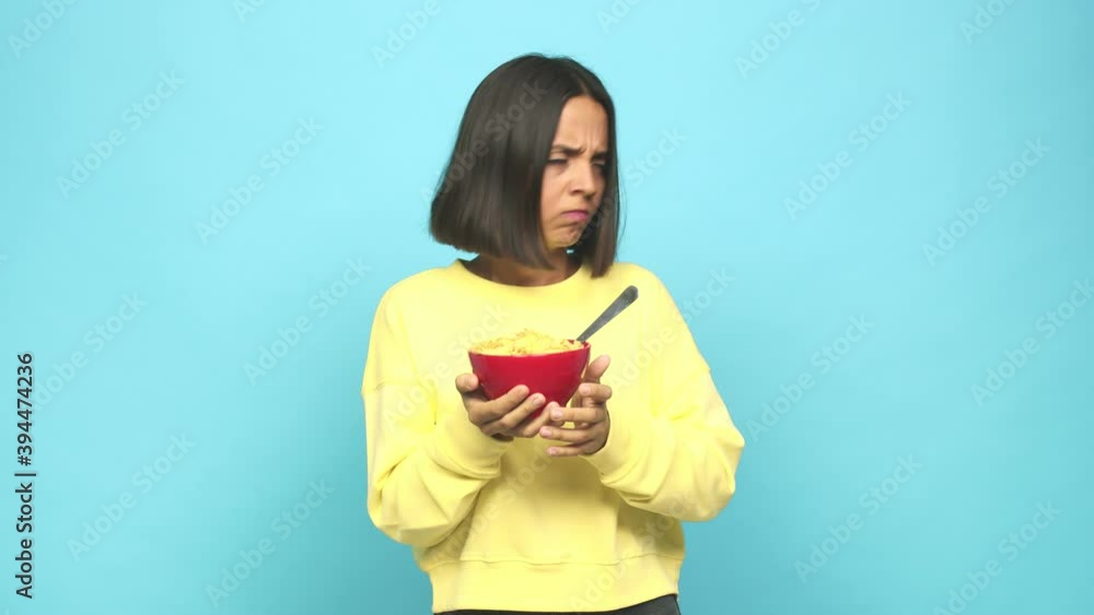 Young latin woman eating a cereals bowl angry and in a bad mood Young latin woman eating a cereals bowl angry and in a bad mood