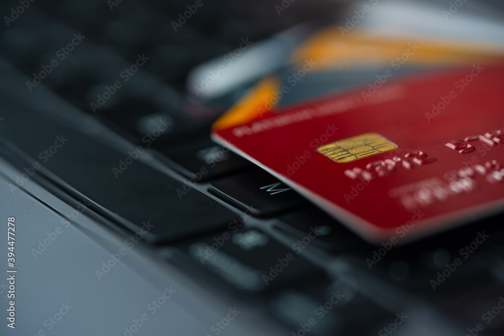 Macro shot of multicolored credit cards on laptop keyboard background. Finance transaction or transfer online pay money concept. Macro shot of multicolored credit cards on laptop keyboard background. Finance transaction or transfer online pay money concept.
