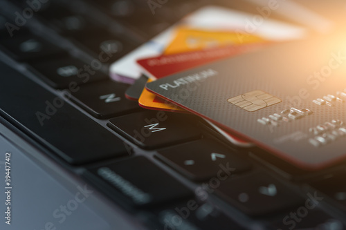 Close-up view of multicolored credit cards on laptop keyboard background. Finance transaction or transfer online pay money concept.