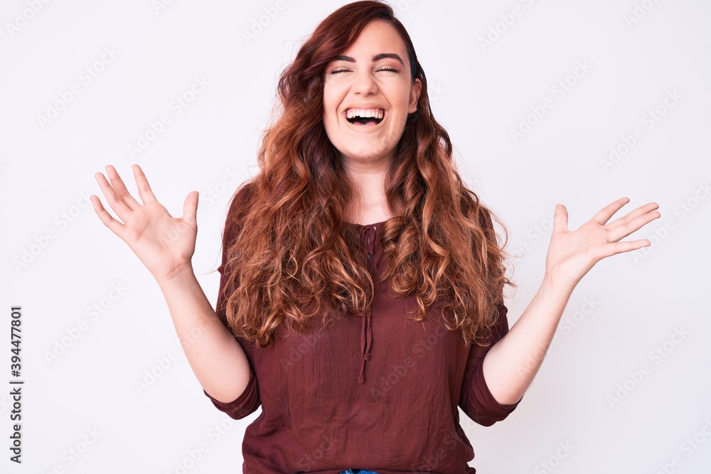 Young beautiful woman wearing casual clothes celebrating mad and crazy for success with arms raised and closed eyes screaming excited. winner concept Young beautiful woman wearing casual clothes celebrating mad and crazy for success with arms raised and closed eyes screaming excited. winner concept