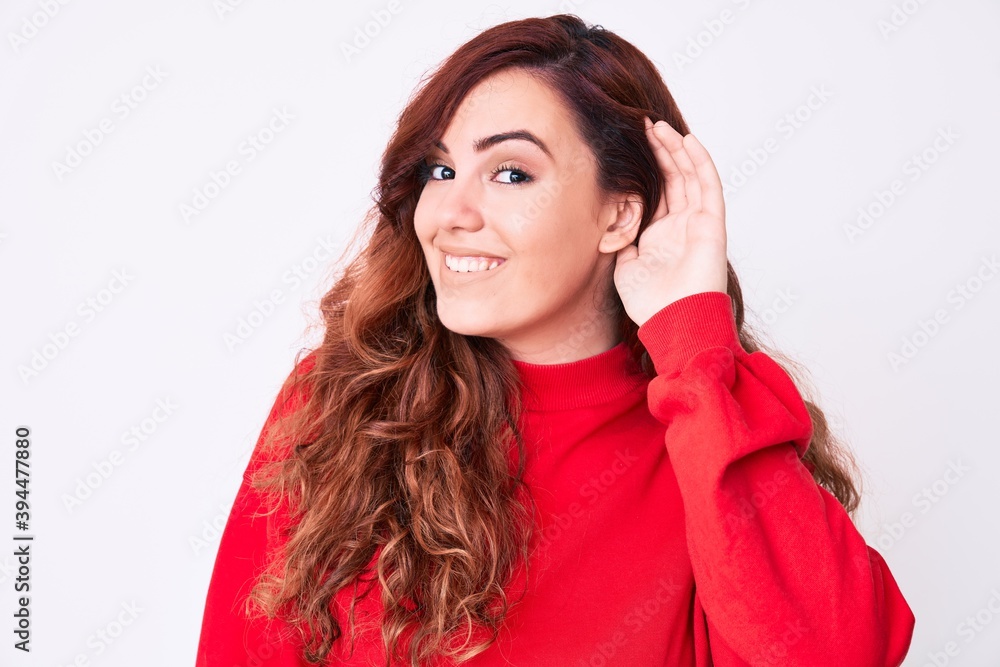 Young beautiful woman wearing casual clothes smiling with hand over ear listening an hearing to rumor or gossip. deafness concept. Young beautiful woman wearing casual clothes smiling with hand over ear listening an hearing to rumor or gossip. deafness concept.